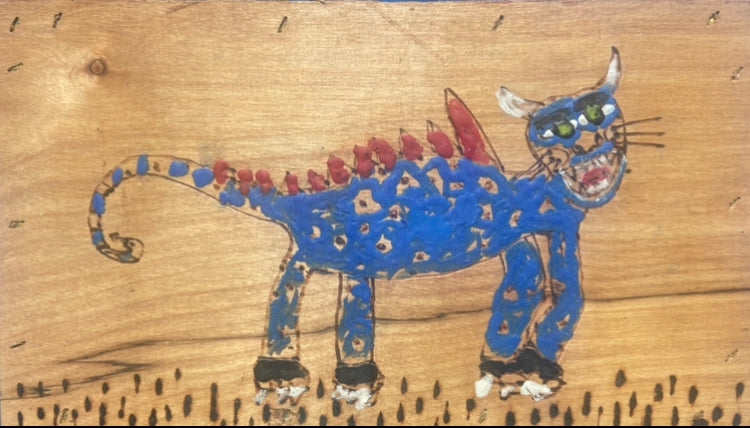 Colorful drawing of a creature on a wooden surface