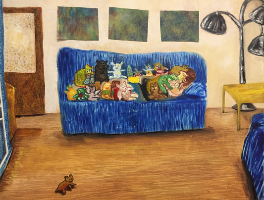Blue couch with cartoon characters in a room with a lamp and wall art.